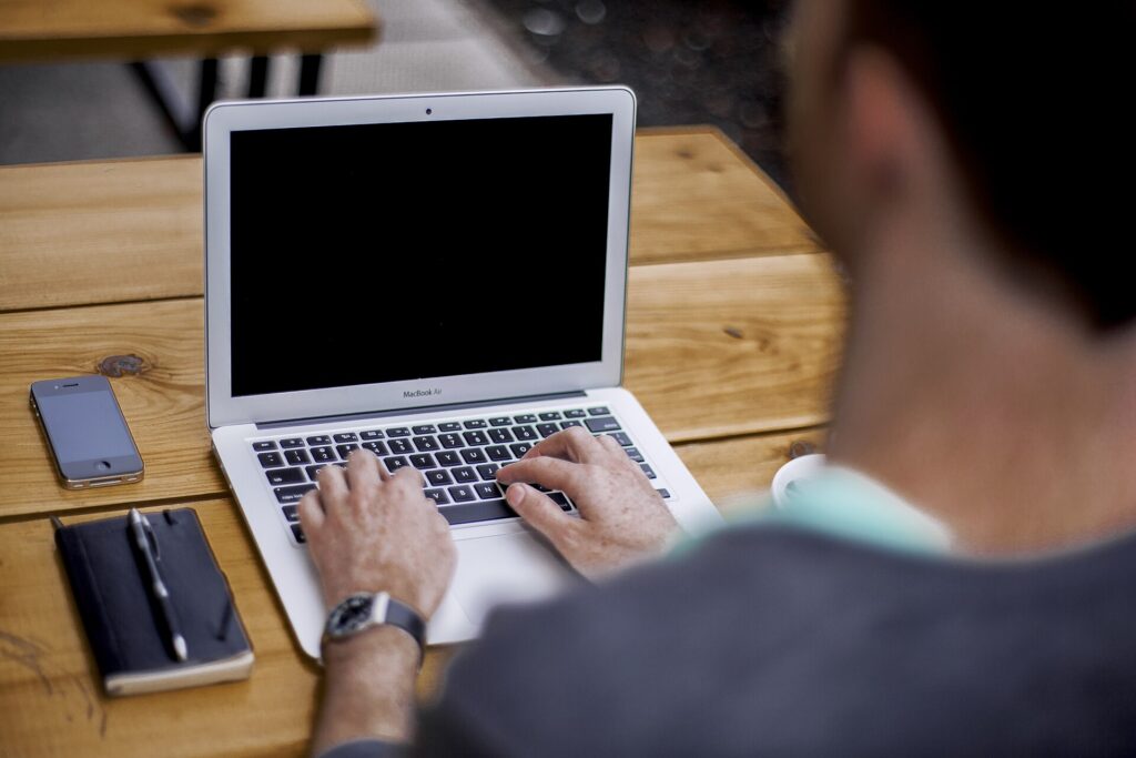1099-K for freelancers: a person working on a laptop, reviewing invoices and tax forms