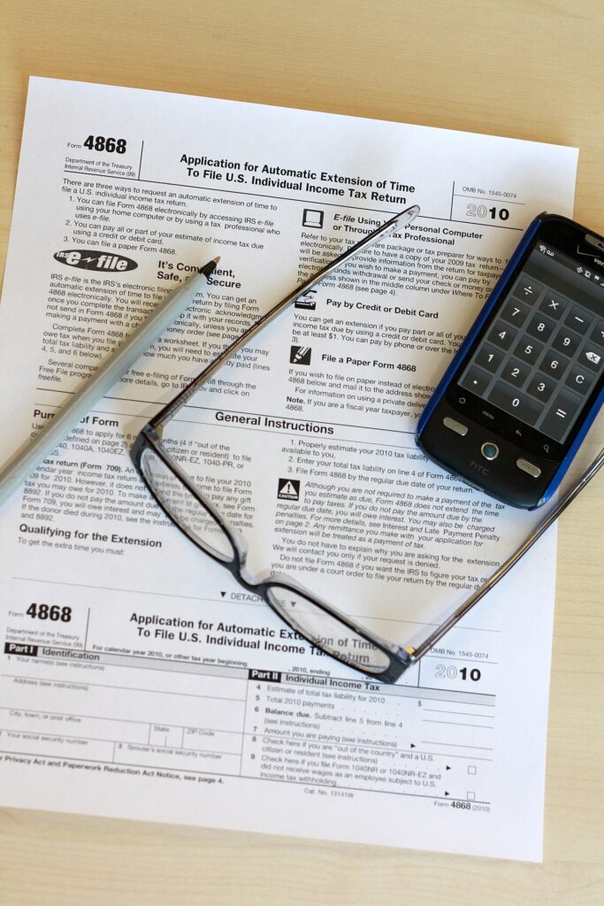 Freelancer reviewing a tax form and calculator to avoid an estimated tax penalty for freelancers