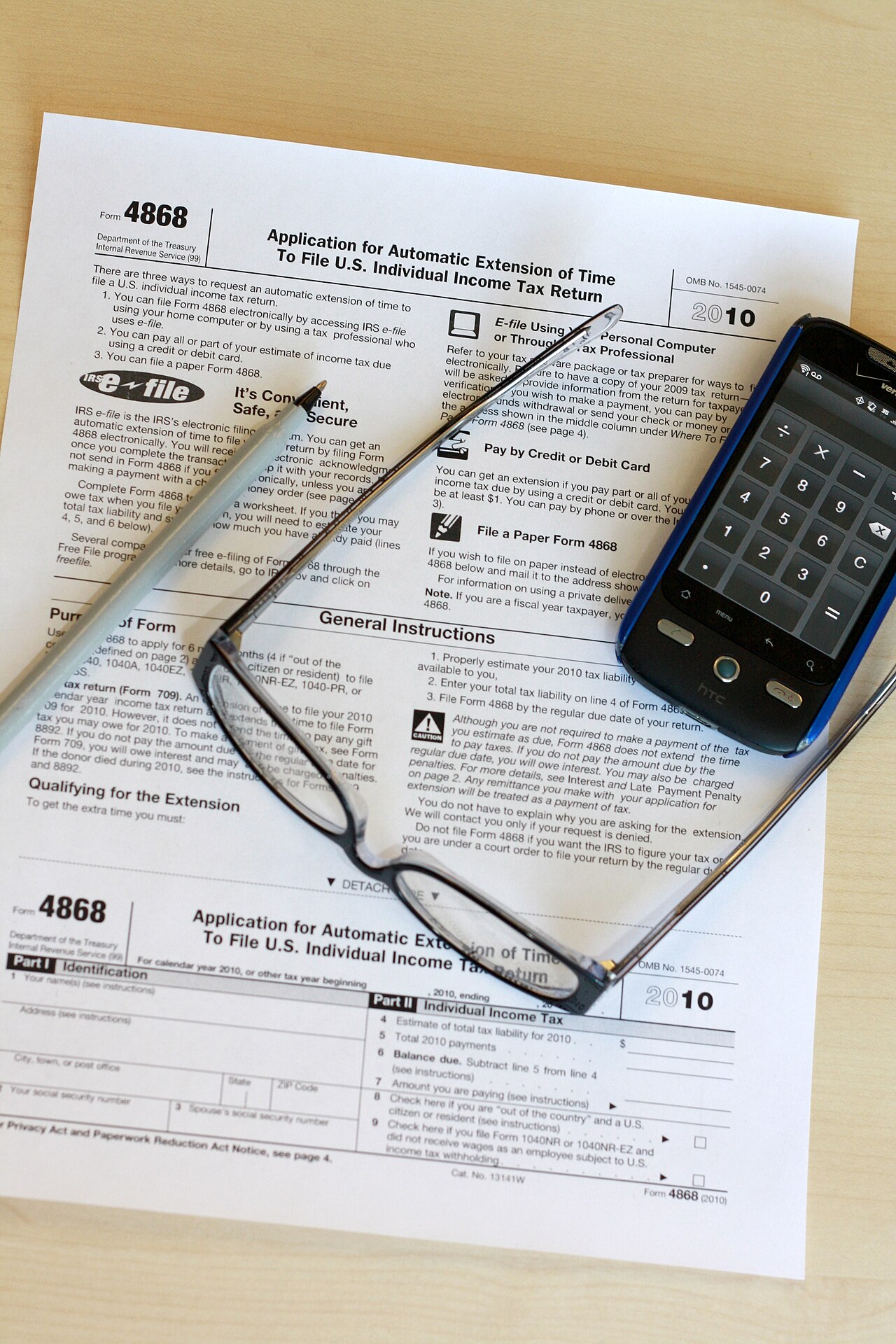 Freelancer calculating an estimated tax penalty for freelancers at a desk with invoices and a calculator